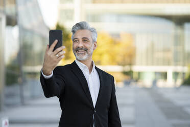 Geschäftsmann nimmt Selfie durch Mobiltelefon - JCCMF04392