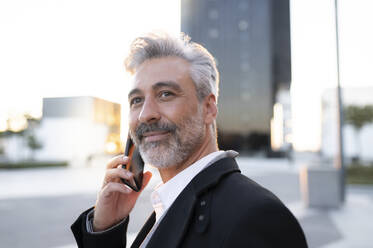 Businessman talking on smart phone - JCCMF04425