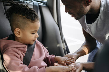 Son touching father's hands in car - VYF00671