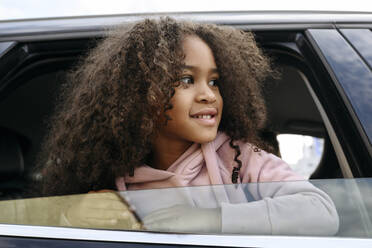Lächelndes Mädchen schaut aus dem Autofenster - VYF00686
