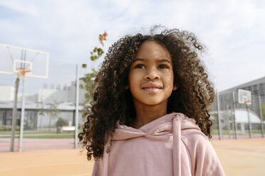 Girl with brown curly hair at sports field - VYF00694