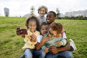 Mann macht Selfie mit Familie über Smartphone im Park - VYF00761