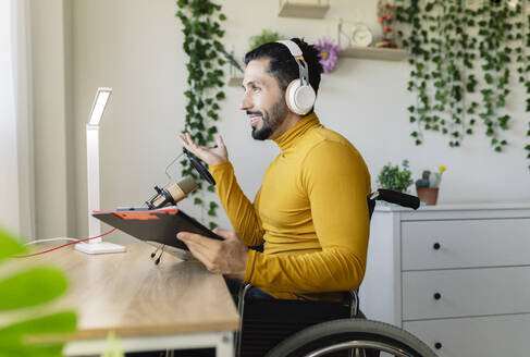 Behinderter männlicher Influencer gestikuliert zu Hause - JCCMF04437