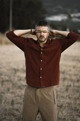 Man covering eyes with rope standing in field - RCPF01435