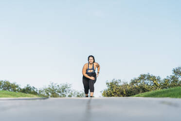 Young female athlete running on road - DAMF00899