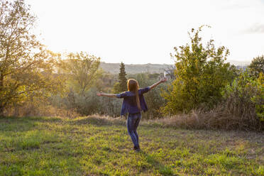 Carefree woman enjoying sunset at countryside - EIF02355