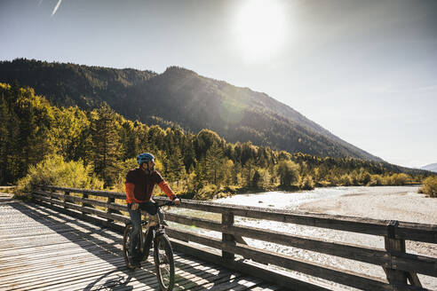 Mann fährt Mountainbike an einem sonnigen Tag - UUF25035