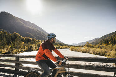 Mann mit Helm beim Radfahren auf der Brücke - UUF25036