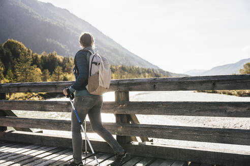 Weiblicher Wanderer mit Rucksack auf Brücke - UUF25055