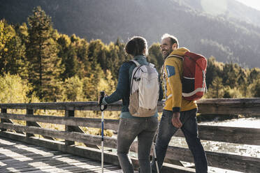 Couple with backpacks walking on bridge - UUF25057