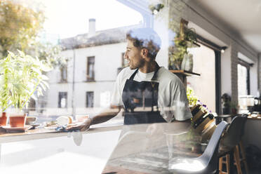 Waiter cleaning table in coffee shop - JCCMF04471