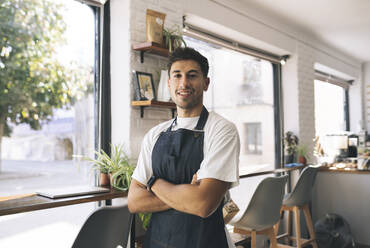 Owner with arms crossed in coffee shop - JCCMF04472