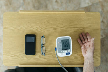 Mann prüft Blutdruck auf dem Tisch zu Hause - JRFF05192