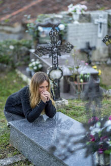 Frau mit gefalteten Händen beim Gebet auf dem Friedhof - OCMF02293