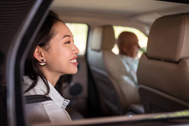 Seitenansicht einer asiatischen Beifahrerin, die im Auto sitzt - ADSF31415