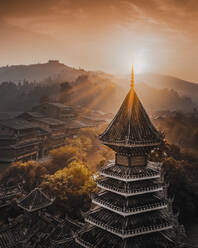 Luftaufnahme eines Turms im Dorf Dong bei Sonnenaufgang in Guizhou, China. - AAEF13236