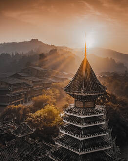 Aerial view of tower in Dong village at sunrise in Guizhou, China. - AAEF13236