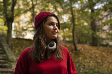 Woman in knit hat contemplating at public park - SSGF00238