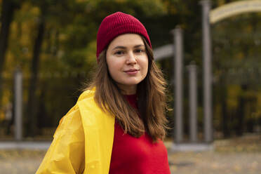 Beautiful woman wearing yellow raincoat in park - SSGF00243