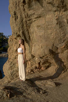 Female athlete meditating on rock - VEGF05149