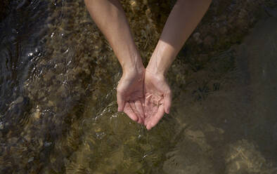 Woman with hands cupped holding water - VEGF05166