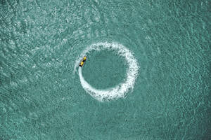 Luftaufnahme einer Person auf einem Jetski, die im Meer kreist, Karibisches Meer, Grand Cul de Sac Marin, Sainte Rose, Les Antilles, Guadeloupe, Ostkaribische Insel. - AAEF13297