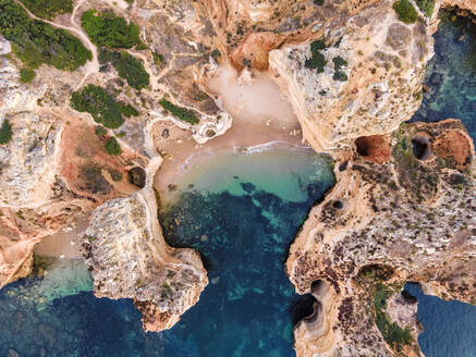 Aerial view of Praia dos Pinheiros, a beautiful paradise beach along the coast with scenic cliffs near Ponta da Piedade, Lagos, Algarve region, Portugal. - AAEF13301