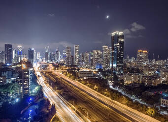 Luftaufnahme der Ayalon-Autobahn am Nordeingang der Stadt Tel-Aviv bei Nacht, die Wolkenkratzer und die Lichter der nachlaufenden Autos, Tel-Aviv, Israel. - AAEF13316