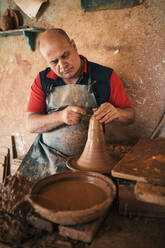 Potter making earthenware in workshop - GRCF01018
