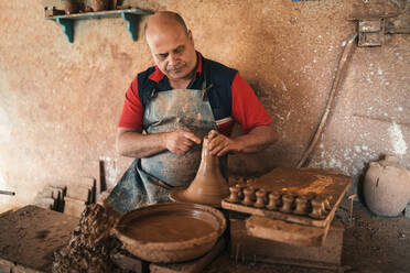 Craftsperson shaping earthenware at pottery - GRCF01021