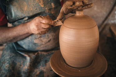 Potter making lid of pot in workshop - GRCF01024