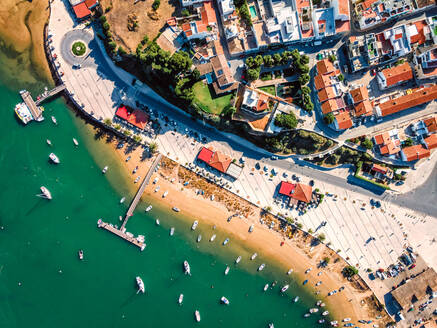 Luftaufnahme von Booten, die am Pier des Stadthafens von Alvor in Ribeira de Odiaxere, Alvor, Region Algarve, Portugal, vor Anker liegen. - AAEF13349