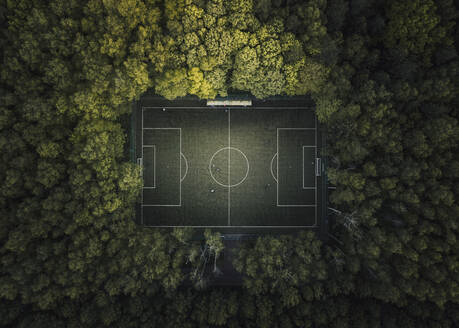 Luftaufnahme eines Fußballplatzes mit Menschen, die Fußball spielen, umgeben von Waldbäumen in der Stadt Moskau, Russland. - AAEF13398