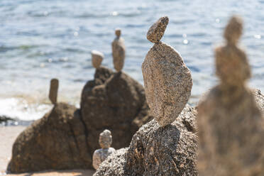 Rocks stacked at beach on sunny day, Lloret De Mar, Catalonia, Spain - JAQF00862