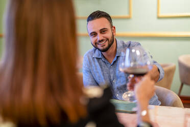 Ehepaar stößt mit Weingläsern im Restaurant an - DLTSF02393