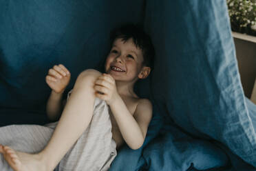 Verspielter Junge unter der Bettdecke im Schlafzimmer - SEAF00008