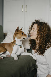 Frau mit lockigem Haar schaut auf Basenji-Hund - SEAF00025