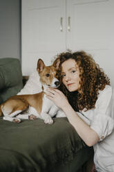 Woman embracing Basenji Dog at home - SEAF00026