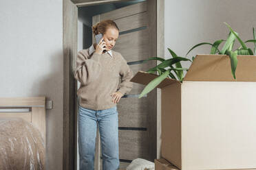 Frau spricht mit Smartphone in neuer Wohnung - VPIF05175