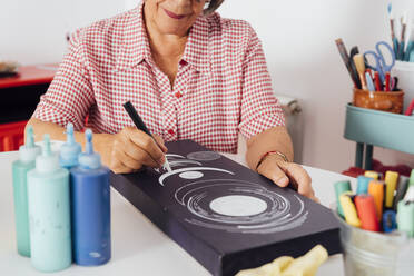 Woman painting on canvas at home - GPF00140