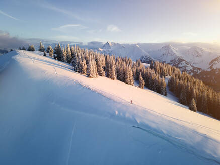 Frau beim Skifahren auf einem schneebedeckten Berg bei Sonnenaufgang, Schonkahler, Tirol, Österreich - MALF00360