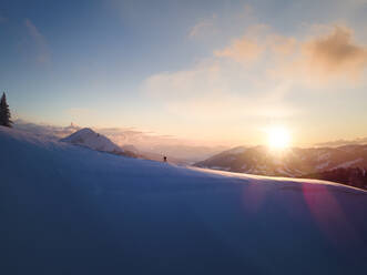 Frau beim Skifahren auf schneebedecktem Berghang bei Sonnenaufgang, Schonkahler, Tirol, Österreich - MALF00361