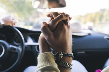 Junges Paar hält Hände im Auto - JCCMF04495
