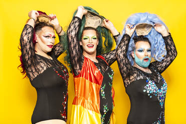 Drag queens in shapewear by pink background stock photo