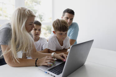 Mutter lehrt ihre Söhne, den Laptop zu Hause zu benutzen - TYF00021