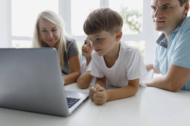 Familie beobachtet Laptop auf dem Tisch zu Hause - TYF00022