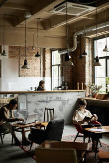 Mann und Frau verbringen ihre Freizeit in einem modernen Cafe - DSHF00048