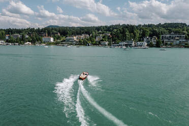 Österreich, Kärnten, Velden am Wörthersee, Luftaufnahme eines Motorbootes mit Kielwasser auf dem türkisfarbenen Wörthersee - DAWF02215