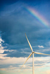 Regenbogen in einem dunklen Himmel über einer Windkraftanlage - CAVF95145