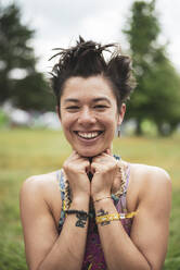 Lächelnde gemischtrassige asiatische Frau mit lustigem Haar auf einem Festival in Polen - CAVF95156
